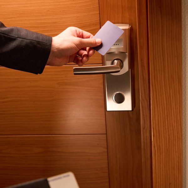 Man hand unlocks a door with plastic key card